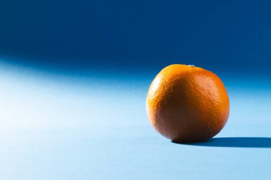 Turuncuyu kapat ve mavi arkaplanı kopyala. Meyve, egzotik meyve, yiyecek, tazelik ve renk kavramı.