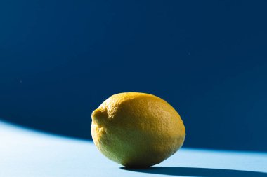 Mavi arka planda limon ve fotokopi alanını kapatın. Meyve, egzotik meyve, yiyecek, tazelik ve renk kavramı.
