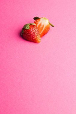 Yarım çilek ve pembe arka plandaki fotokopi alanını kapatın. Meyve, meyve, yiyecek, tazelik ve renk kavramı.