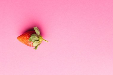 Çileği kapat ve pembe arka plandaki boşluğu kopyala. Meyve, meyve, yiyecek, tazelik ve renk kavramı.