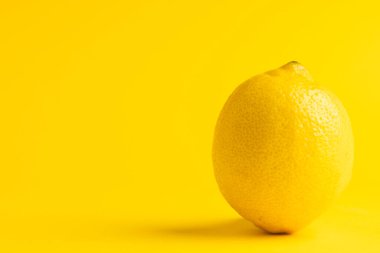 Limonu kapat ve sarı arkaplanda kopyala. Meyve, egzotik meyve, yiyecek, tazelik ve renk kavramı.