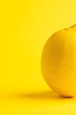Limonu kapat ve sarı arkaplanda kopyala. Meyve, egzotik meyve, yiyecek, tazelik ve renk kavramı.