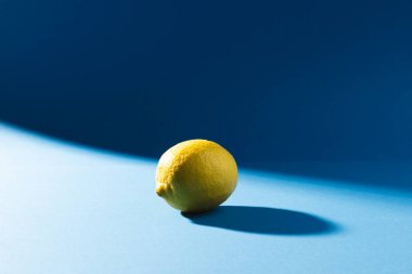 Mavi arka planda limon ve fotokopi alanını kapatın. Meyve, egzotik meyve, yiyecek, tazelik ve renk kavramı.