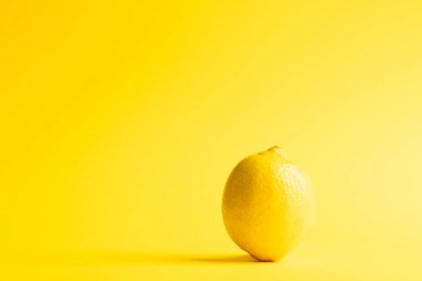 Limonu kapat ve sarı arkaplanda kopyala. Meyve, egzotik meyve, yiyecek, tazelik ve renk kavramı.