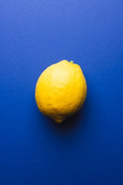 Mavi arka planda limon ve fotokopi alanını kapatın. Meyve, egzotik meyve, yiyecek, tazelik ve renk kavramı.