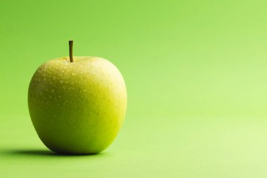 Yeşil elmayı kapat ve yeşil arkaplanda kopyala. Meyve, yemek, tazelik ve renk kavramı.