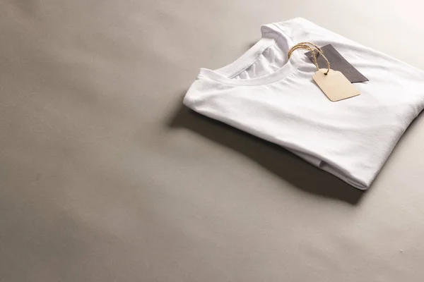 折叠式白色T恤 带有标签 带有褐色背景的复制空间 色彩和面料概念 — 图库照片