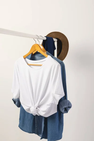 白いTシャツ デニムのシャツは白い背景のコピースペースが付いている衣服の柵から掛かります ファッション ファブリックコンセプト — ストック写真