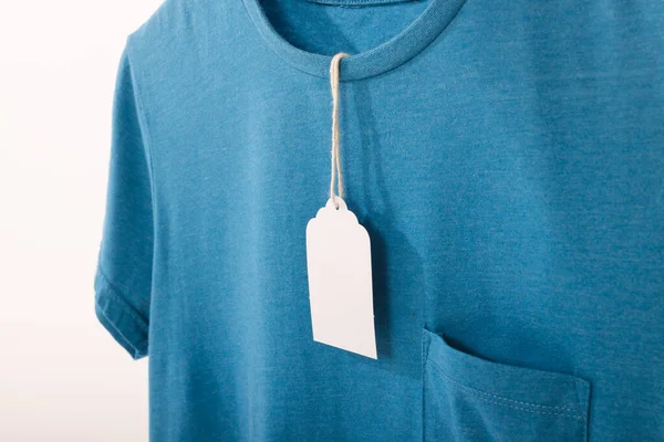 蓝色T恤 带有标签 并在白色背景上复制空格 色彩和面料概念 — 图库照片