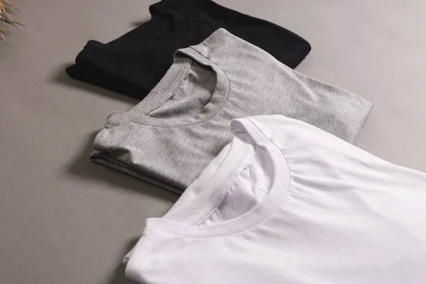 三件T恤衫 底色灰暗 有复制空间 色彩和面料概念 — 图库照片