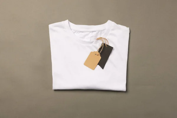 Składana Biała Koszulka Tagami Miejscem Ksero Brązowym Tle Moda Ubrania — Zdjęcie stockowe