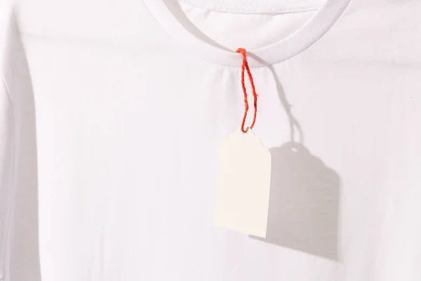 Camiseta Blanca Con Etiqueta Con Espacio Copia Sobre Fondo Blanco —  Fotos de Stock