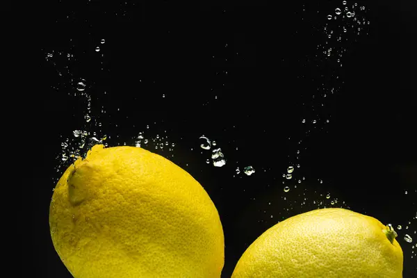Detailní Záběr Citronů Padajících Vody Kopírovacím Prostorem Černém Pozadí Ovoce — Stock fotografie