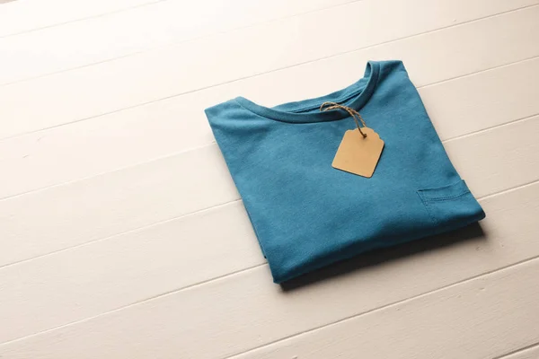 Primer Plano Disposición Plana Camiseta Azul Con Etiqueta Espacio Copia — Foto de Stock
