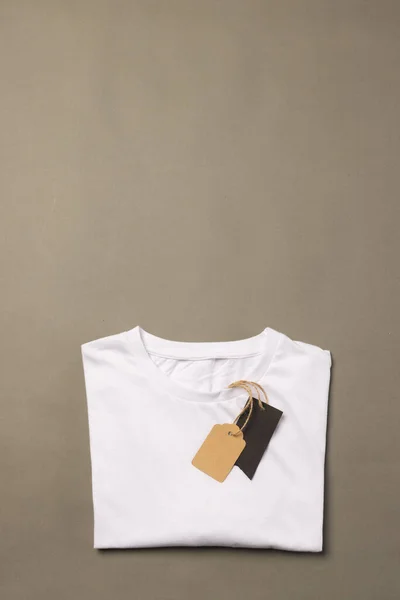 Skládané Bílé Tričko Tagy Kopírovacím Prostorem Hnědém Pozadí Móda Oblečení — Stock fotografie