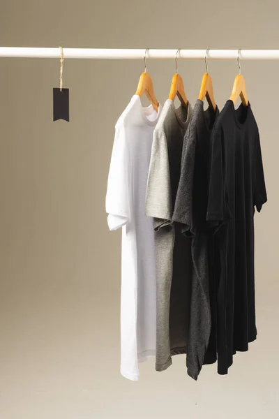 四件T恤衫挂在衣架上 在灰色背景上复制空间 色彩和面料概念 — 图库照片