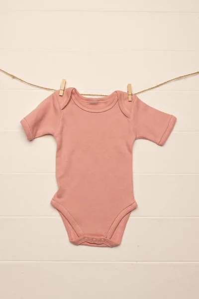 ピンクの赤ん坊は白い背景のコピースペースが付いている衣服のペグとぶら下がります ベビーファッション ファブリックコンセプト — ストック写真