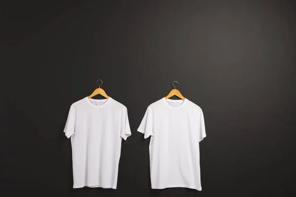 Две Белые Футболки Вешалках Копия Пространства Черном Фоне Мода Одежда — стоковое фото