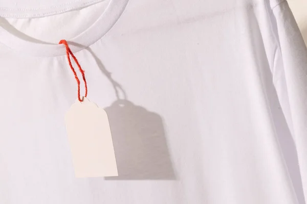 Camiseta Blanca Con Etiqueta Con Espacio Copia Sobre Fondo Blanco —  Fotos de Stock