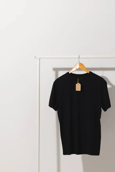 Camiseta Negra Con Etiqueta Colgando Perchero Con Espacio Para Copiar — Foto de Stock