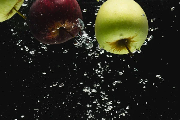 黒い背景のコピースペースで水に落ちるリンゴのクローズアップ フルーツ 食べ物 新鮮さ カラーコンセプト — ストック写真
