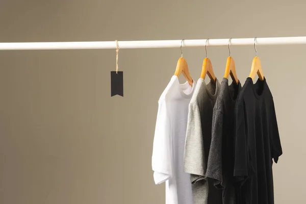 Vier Shirts Hangers Hangend Aan Kledingrail Kopieer Ruimte Grijze Achtergrond — Stockfoto
