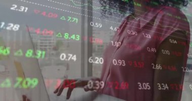 Çift ırklı bir kadının dizüstü bilgisayarda ayakta durması ve çalışması üzerine renkli ticaret kurulunun animasyonu. Dijital bileşik, çoklu pozlama, iş, borsa, ofis ve teknoloji kavramı.