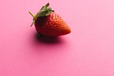 Çileği kapat ve pembe arka plandaki boşluğu kopyala. Meyve, meyve, yiyecek, tazelik ve renk kavramı.