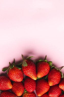 Çilekleri kapatın ve pembe arka planda kopyalayın. Meyve, meyve, yiyecek, tazelik ve renk kavramı.
