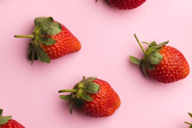 Çilekleri kapatın ve pembe arka planda kopyalayın. Meyve, meyve, yiyecek, tazelik ve renk kavramı.