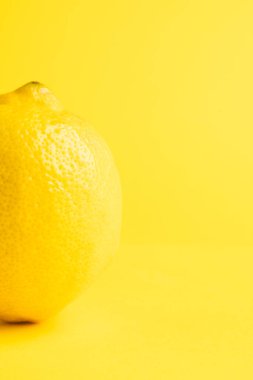 Limonu kapat ve sarı arkaplanda kopyala. Meyve, egzotik meyve, yiyecek, tazelik ve renk kavramı.