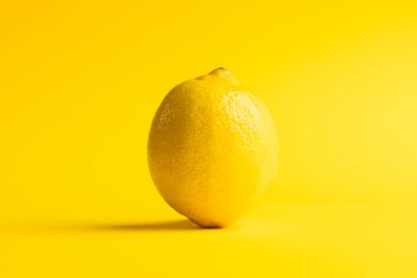 Limonu kapat ve sarı arkaplanda kopyala. Meyve, egzotik meyve, yiyecek, tazelik ve renk kavramı.