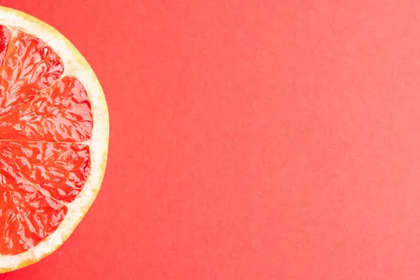 Nahaufnahme Einer Scheibe Roter Grapefruit Und Kopierfläche Auf Rotem Hintergrund — Stockfoto