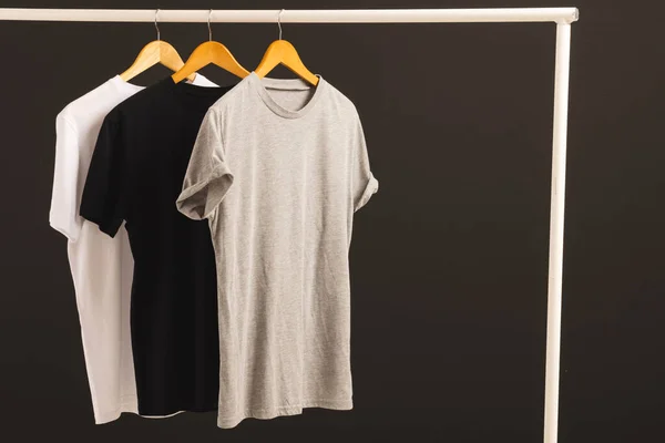 Tři Trička Ramínka Visící Zábradlí Oblečení Kopírujte Prostor Černém Pozadí — Stock fotografie