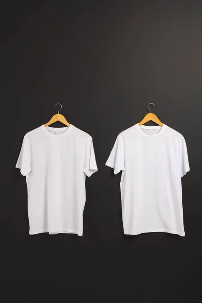 Dos Camisetas Blancas Perchas Espacio Para Copiar Sobre Fondo Negro —  Fotos de Stock