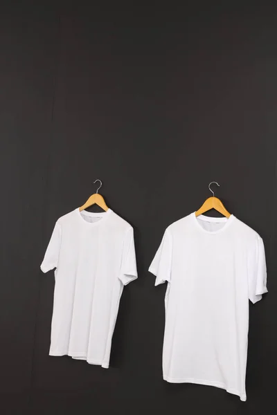 Dos Camisetas Blancas Perchas Espacio Para Copiar Sobre Fondo Negro —  Fotos de Stock