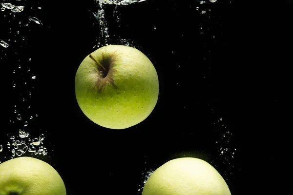 黒い背景のコピースペースで水に落ちる緑のリンゴのクローズアップ フルーツ 食べ物 新鮮さ カラーコンセプト — ストック写真