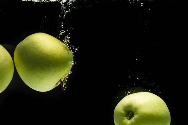 黒い背景のコピースペースで水に落ちる緑のリンゴのクローズアップ フルーツ 食べ物 新鮮さ カラーコンセプト — ストック写真