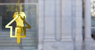 Altın ev anahtarlarını, fotokopi alanı olan binanın bulanık görüntüsüne karşı asma animasyonu. Yerleştirme ve emlak konsepti