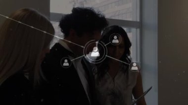 Bağlı ikonlar ve kar yağışı animasyonları, çeşitli iş arkadaşları dijital tablet raporlarını tartışıyor. Dijital bileşik, çoklu pozlama, iletişim, kış, takım çalışması ve teknoloji kavramı.