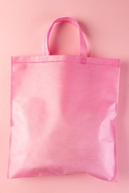 Pembe arkaplanda fotokopi alanı olan pembe brandayı kapat. Alışveriş, çanta, renk, kumaş, doku ve malzeme kavramı.