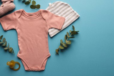 Pembe bebek büyümesi, şapkası, kuklası ve mavi arka planda fotokopi alanı olan pembe ayakkabıları. Bebek modası, kıyafetler, renk ve kumaş konsepti.