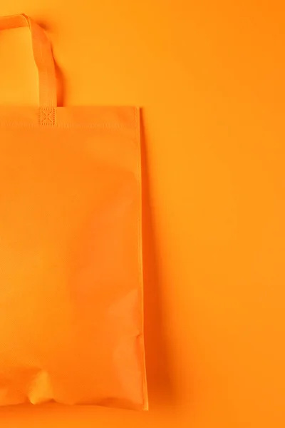Close up of orange canvas bag with copy space on orange background. Shopping, bag, colour, fabric, texture and materials concept.