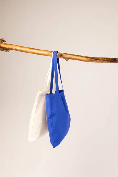 White Blue Canvas Bags Hanging Wooden Branch Copy Space White — Stock Photo, Image