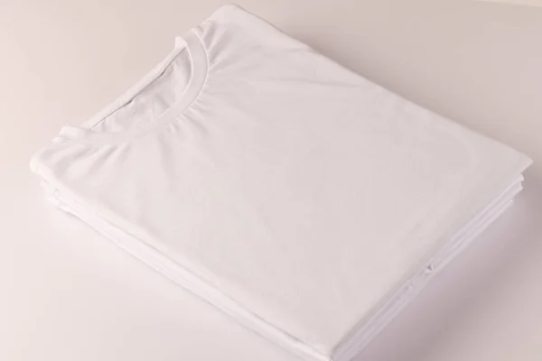 白いTシャツのスタックと白い背景にスペースをコピーします ファッション ファブリックコンセプト — ストック写真