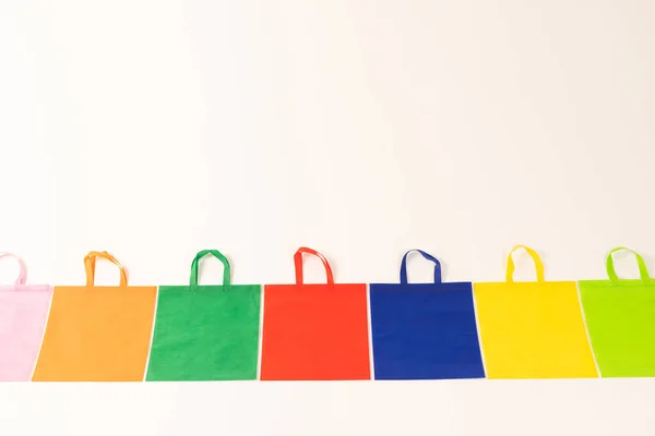 白い背景のコピースペースが付いている多色のキャンバスの袋の列 ショッピング バッグ カラー ファブリック テクスチャ 素材コンセプト — ストック写真