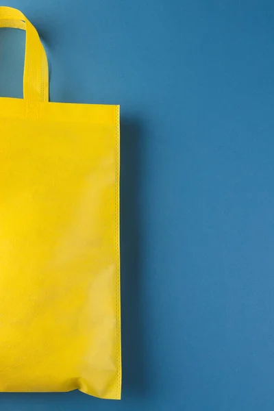 青い背景のコピースペースが付いている黄色いキャンバスの袋の閉鎖 ショッピング バッグ カラー ファブリック テクスチャ 素材コンセプト — ストック写真