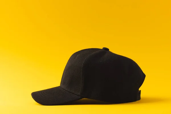 黒い野球帽と黄色の背景にスペースをコピーする ファッション ファブリックコンセプト — ストック写真