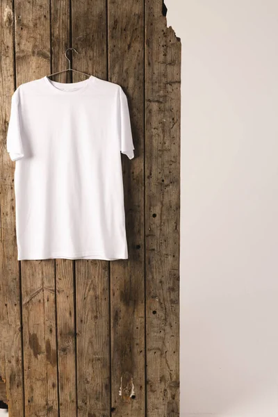 衣架上的白色T恤和木制背景上的复制空间 色彩和面料概念 — 图库照片