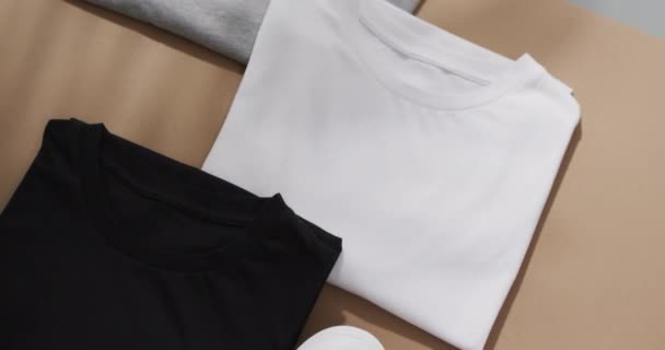 茶色と灰色の背景にコピースペースを持つ多色Tシャツの平らなレイのビデオ ファブリック テクスチャ 材料コンセプト — ストック動画